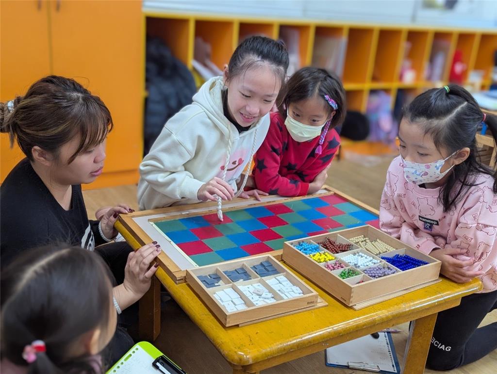 教育園丁的話圖片孩子們正透過蒙特梭利乘法板進行有趣的數學探索，透過具體操作教具，把抽象的乘法概念轉化為可觸可見的經驗。
